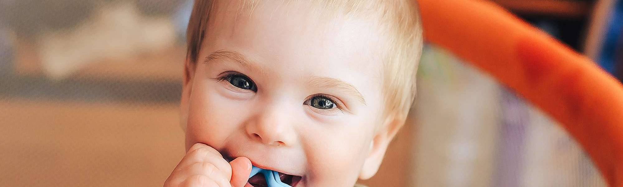 Baby smiling with a biter