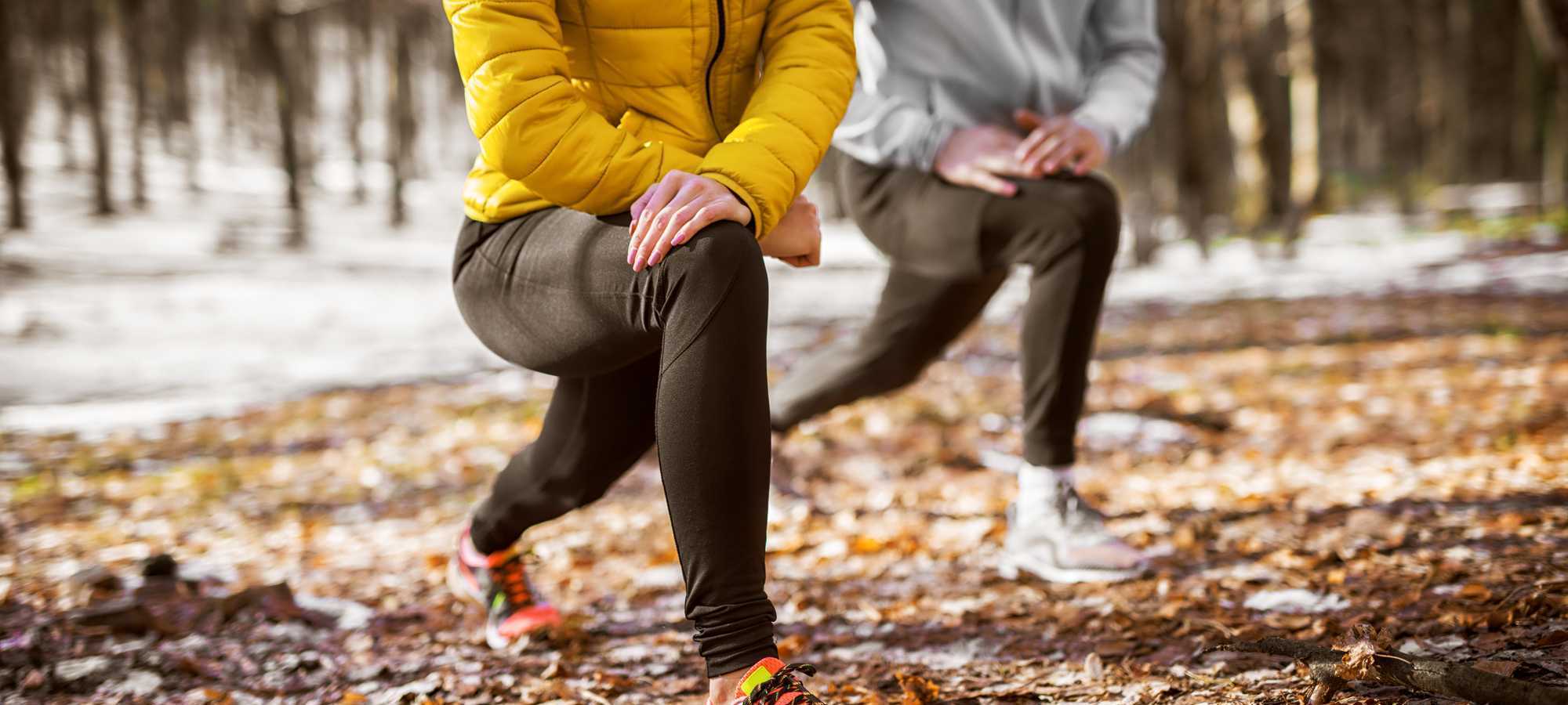 Two runners lunging in a frosty forest