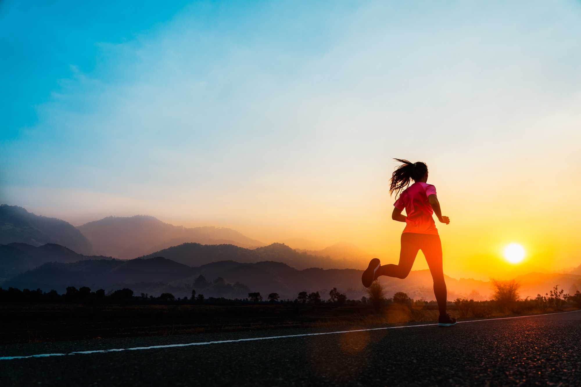 Woman on a run with a sunset in the background