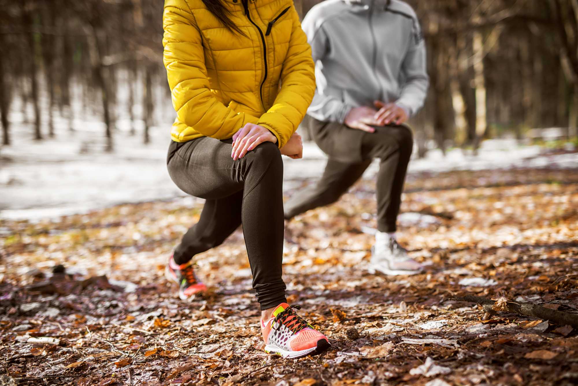 Two runners lunging in a frosty forest