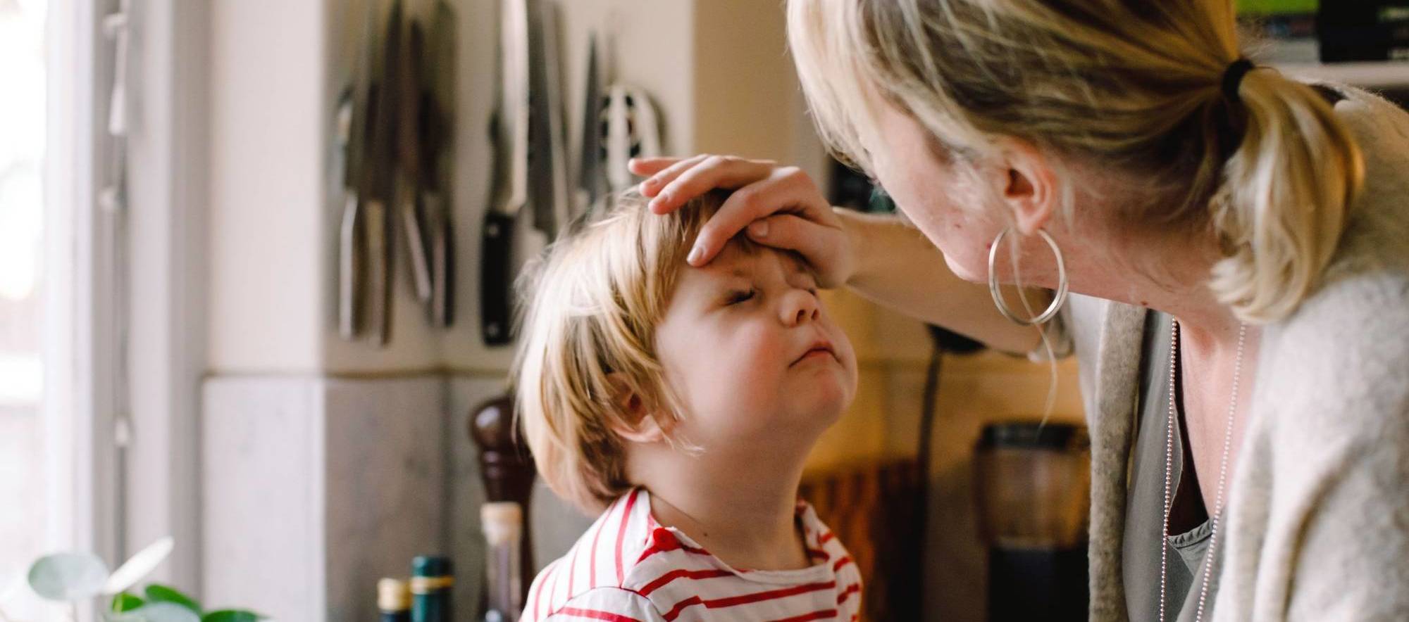 Mum checking her son's fever