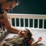 Father Interacting with Baby in Crib