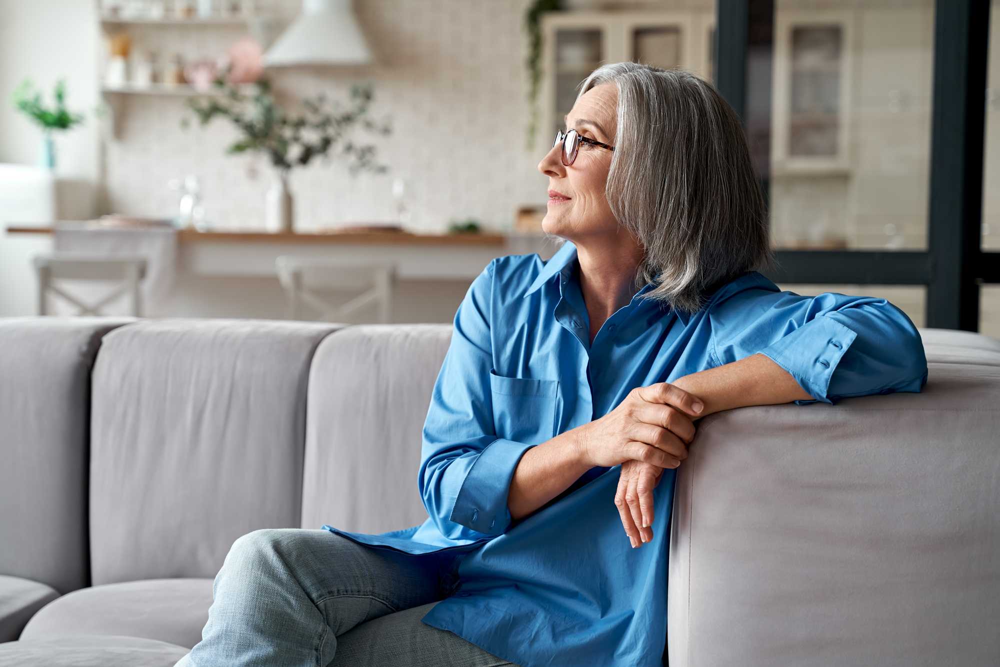 Woman sat on a sofa looking out of a window